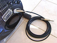 Canare GS-6 Guitar/instrument Cable with black jacket connected to a guitar with a Canare F-15 1/4" TS plug